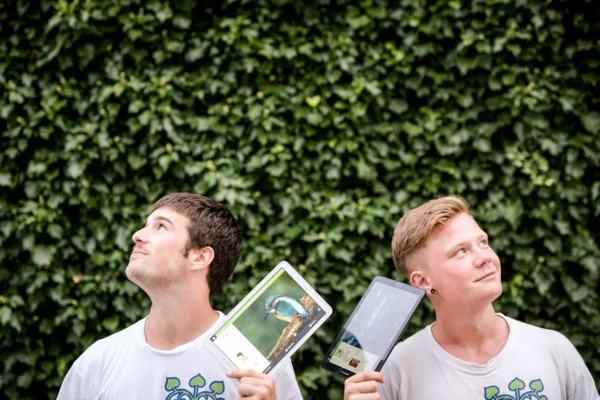 Zwei Fundraiser halten ihre Tablets hoch