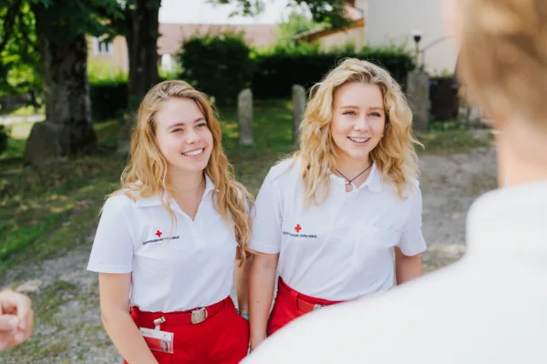 Zwei lächelnde Fundraiserinnen in Rote-Kreuz-Uniform