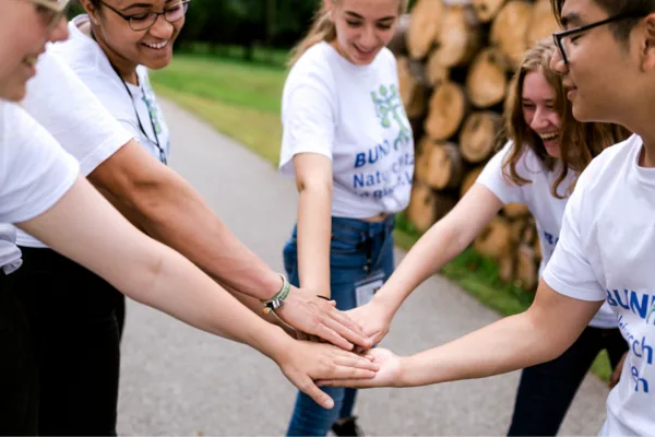 Eine Gruppe Fundraiser schlägt im Kreis ein