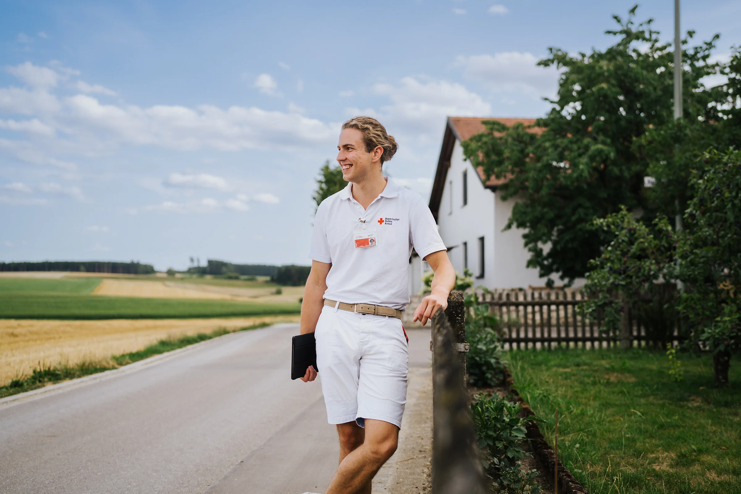 Ein Fundraiser steht an einer Landstraße zwischen Feldern