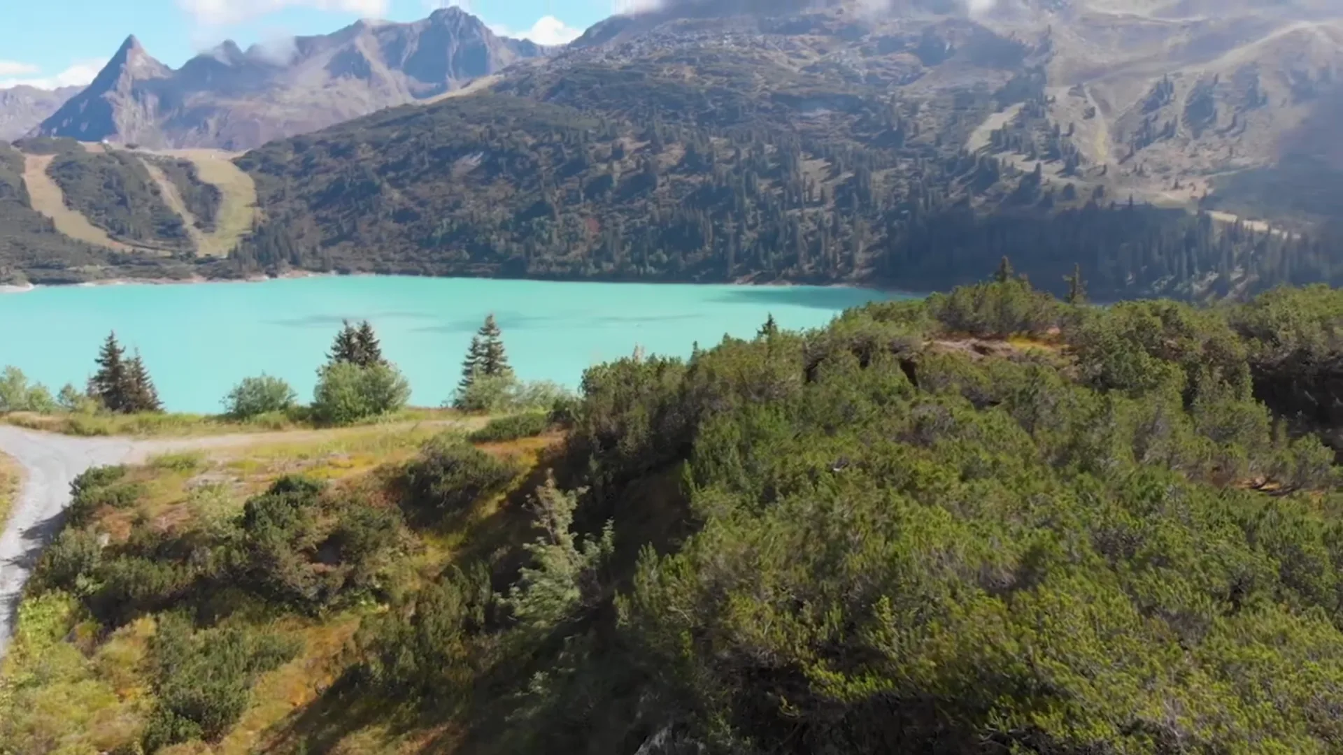 Blick über einen türkisen Stausee in den österreichischen Bergen
